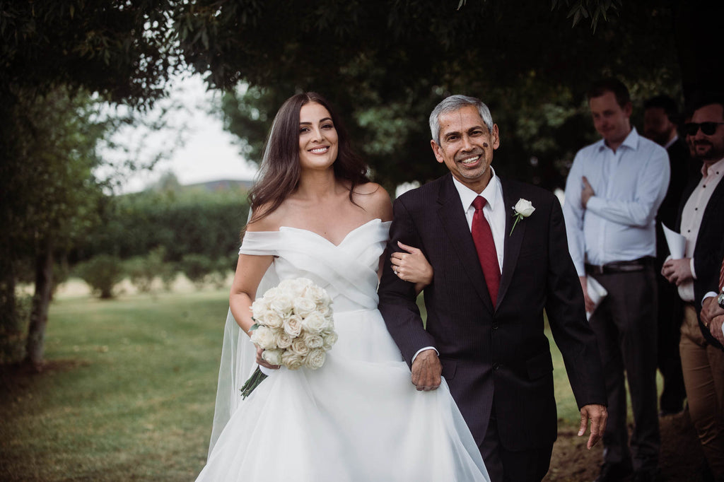 Walking towards the love of her life at this mudgee wedding. Long stem imported white roses tied with ribbon by Mudgee Monkey florist and stylist 